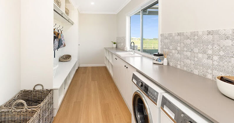 Long laundry room with hooks and window, sink